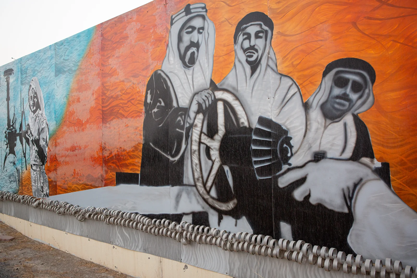 A mural adjacent to the headquarters of the Kuwait Oil Company depicts a group of men turning on an oil tap.